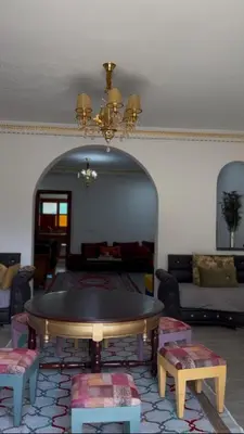 a living room with a table and a couch at Riad suite for families and groups in Marrakech