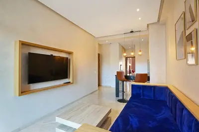 a living room with a blue couch and a flat screen tv at New Elegant and cozy appartement next to carre eden in Marrakech