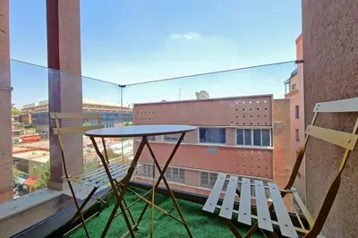 a table and two chairs on a balcony with a window at New Elegant and cozy appartement next to carre eden in Marrakech