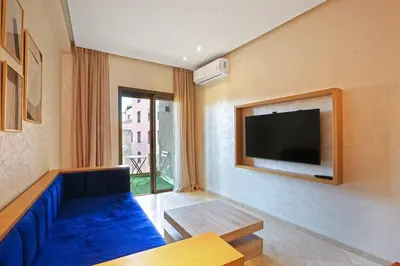 a living room with a blue couch and a tv at New Elegant and cozy appartement next to carre eden in Marrakech