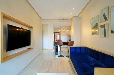 a living room with a blue couch and a television at New Elegant and cozy appartement next to carre eden in Marrakech