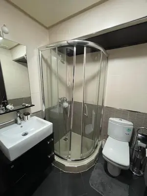 a bathroom with a shower and a toilet and a sink at Apartement de Luxe mit Tiefgarage in Marrakech