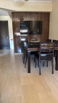 a dining room with a table and chairs and a television at Apartement de Luxe mit Tiefgarage in Marrakech