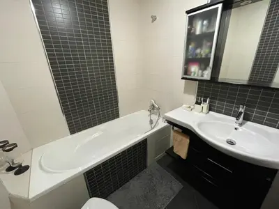 a bathroom with a sink and a tub and a toilet at Apartement de Luxe mit Tiefgarage in Marrakech