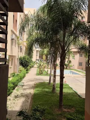 two palm trees in front of a building at Elegant & Comfortable Apartment in Marrakesh in Marrakech