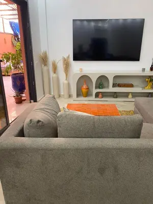 a living room with a couch and a flat screen tv at Appartement luxueux Gueliz in Marrakech
