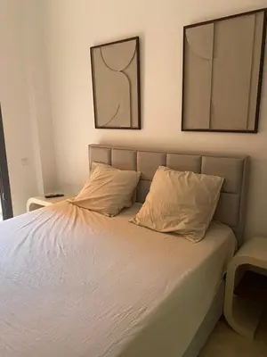 a bedroom with a bed with two pictures on the wall at Appartement luxueux Gueliz in Marrakech