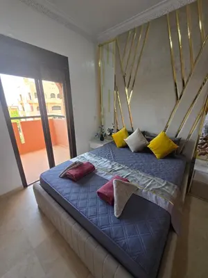 a bedroom with a bed with colorful pillows on it at Luxury Apartment in Marrakech Premium Village 5 Pools free Parking in Marrakech