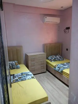 a room with two beds and a dresser in it at Cozy with Moroccan flair in Marrakech