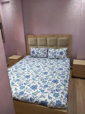 a bed with a blue and white comforter and two pillows at Cozy with Moroccan flair in Marrakech