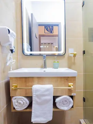 a bathroom with a sink and a mirror and towels at Cozy Apt Close to Gueliz Medina in Marrakech