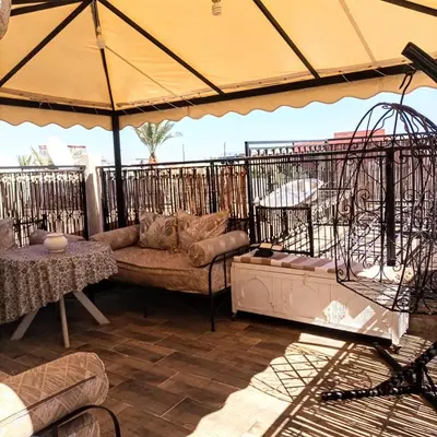 a patio with a couch and an umbrella at Riad Malika et Cristina in Marrakech