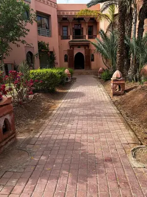 a walkway in front of a building with palm trees at 2 bedroom palmeraie, pools & 3 terraces in Marrakech