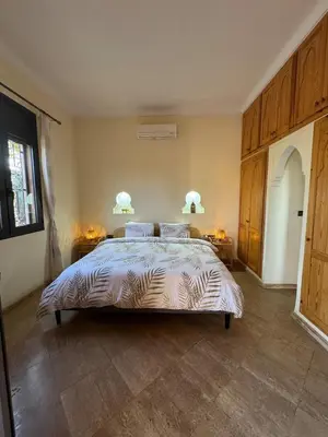 a bedroom with a large bed with two night stands at Splendide Villa avec piscine in Marrakech