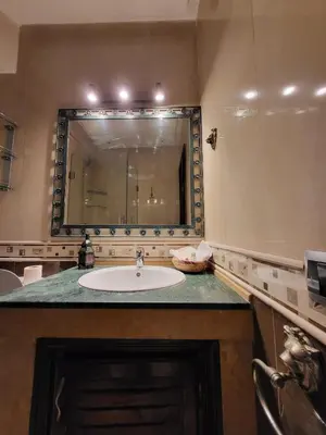 a bathroom with a sink and a large mirror at Palace-Apartment-Marrakech in Marrakech
