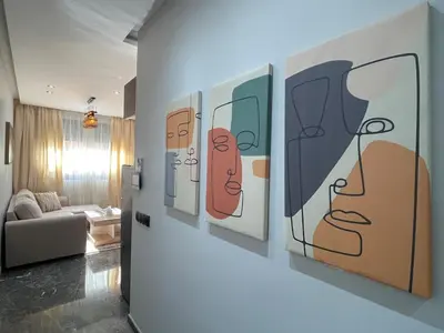 a room with paintings of faces on the wall at High-End Cozy and Modern Studio in Marrakech