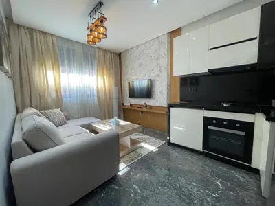 a living room with a couch and a tv at High-End Cozy and Modern Studio in Marrakech