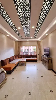 a large living room with a couch and a tv at MELBARI Central-Appart in Marrakech