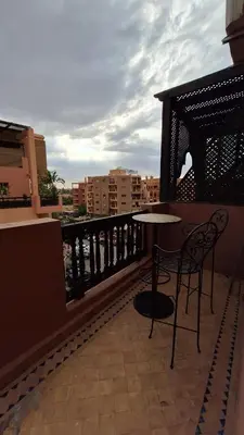 a balcony with a table and chairs on a balcony at MELBARI Central-Appart in Marrakech
