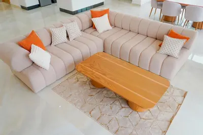 a brown couch with pillows and a wooden coffee table at Villa Emeraude 15 minutes du centre in Marrakech