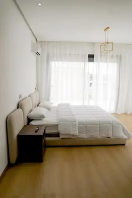 a bedroom with a large bed and a large window at Villa Emeraude 15 minutes du centre in Marrakech
