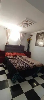 a bedroom with a bed and a checkered floor at Appartement à louer in Marrakech