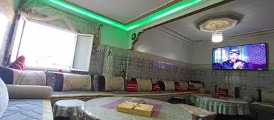 a living room with a couch and a tv at Appartement à louer in Marrakech