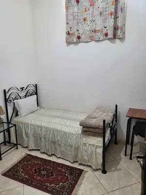 a bedroom with a bed and a table and a rug at Maison D'hôte Dar ALBIDAWI CH5 in Marrakech