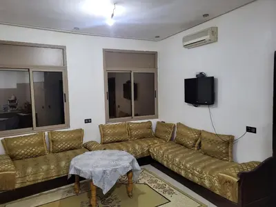 a living room with a couch and a tv at Maison D'hôte Dar ALBIDAWI CH5 in Marrakech