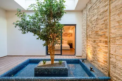 a tree in a pool next to a brick wall at Villa cancun resort Luxury Spa-cinéma & jacuzzi in Marrakech