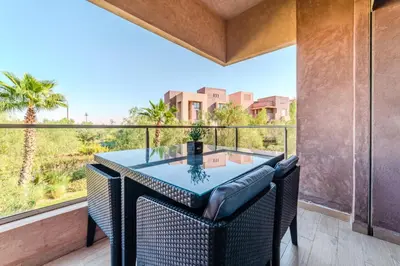 a table and chairs on a balcony with a view at Elegant Appartement Piscine Golf et Wifi in Marrakech