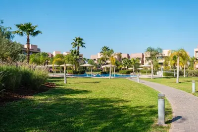 a path through a park with palm trees at Elegant Appartement Piscine Golf et Wifi in Marrakech