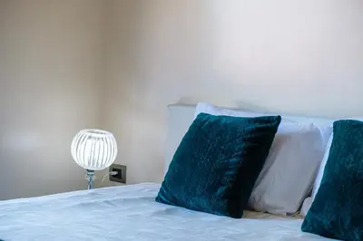 a bed with two blue pillows on top of it at Elegant Appartement Piscine Golf et Wifi in Marrakech