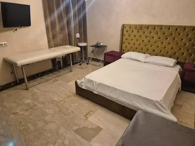 a bedroom with a bed and a bench and a tv at Comfort and Style in the Heart of the City - Villa T in Marrakech