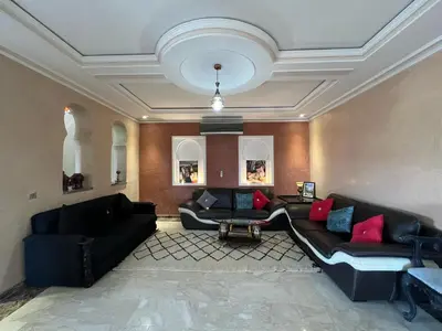 a living room with black couches and red pillows at Comfort and Style in the Heart of the City - Villa T in Marrakech