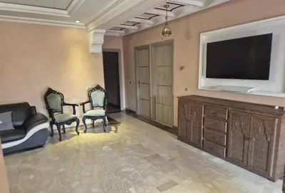 a living room with a television and a table and chairs at Comfort and Style in the Heart of the City - Villa T in Marrakech