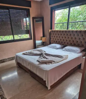 a bedroom with a large bed with a large window at Comfort and Style in the Heart of the City - Villa T in Marrakech