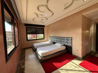 a bedroom with two beds and a red rug at Comfort and Style in the Heart of the City - Villa T in Marrakech