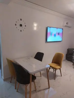 a dining room with a table and chairs and a clock at marrakech geliz in Marrakech