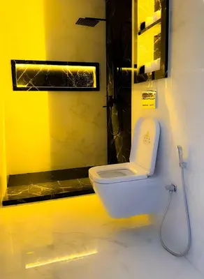 a bathroom with a white toilet and a yellow wall at marrakech geliz in Marrakech