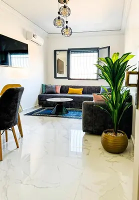 a living room with a couch and a plant at marrakech geliz in Marrakech