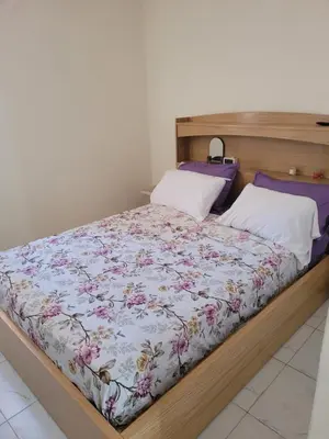 a bed with a floral comforter and two pillows at japoniya in Marrakech