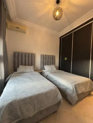 two beds sitting next to each other in a bedroom at Elegant Apartment Marrakech in Marrakech