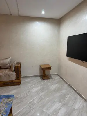 a living room with a couch and a flat screen tv at Appartement moderne et chic in Marrakech