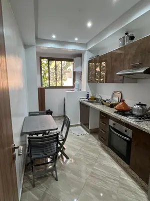 a kitchen with a table and a table and chairs at Appartement moderne et chic in Marrakech