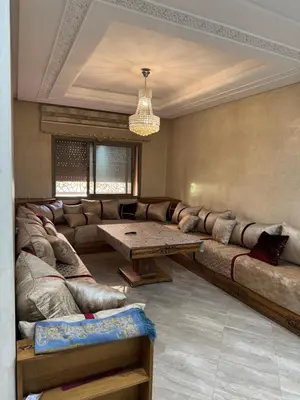 a living room with a large couch and a table at Appartement moderne et chic in Marrakech