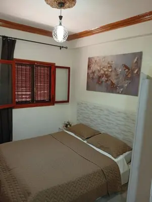 a bedroom with a bed and a painting on the wall at Mhamid airport in Marrakech