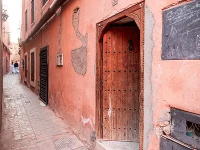 a large wooden door on the side of a building at Dar LalaFadma-Pvt 1BR Studio-1min to Bahia Palace in Marrakech