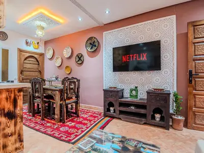 a living room with a tv on a wall at Dar LalaFadma-Pvt 1BR Studio-1min to Bahia Palace in Marrakech