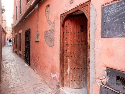 a large wooden door on the side of a building at Dar LalaFadma-Pvt 1BR Studio-1min to Bahia Palace in Marrakech